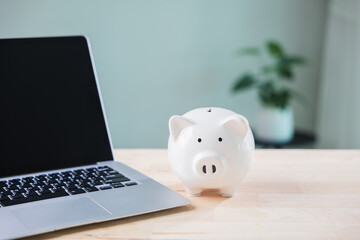 piggy bank e learning education financial money elearning internet sits on wooden desk beside laptop computer for online distance learning and saving for university digital courses