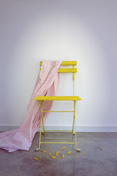 Yellow chair with pink material draped over