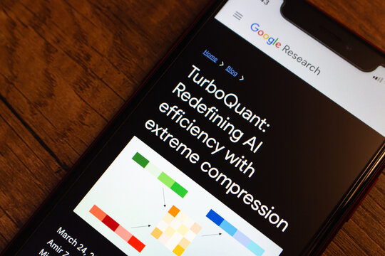 Mexico City, MEXICO - Mar 31 2026 : Close-up of a smartphone on a wooden surface showing the full title of Google Research's blog post "TurboQuant: Redefining AI efficiency with extreme compression".