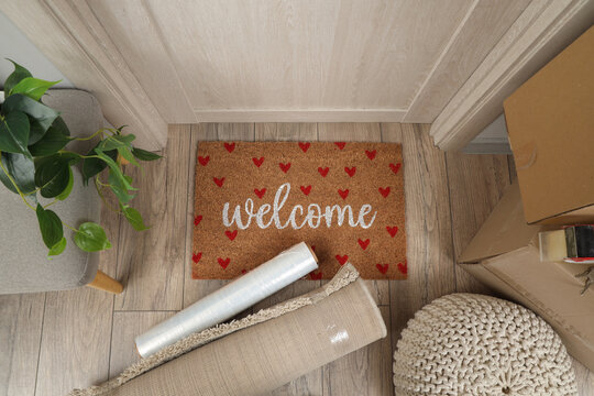 Doormat with stretch wrap and carpet in hallway on moving day, top view