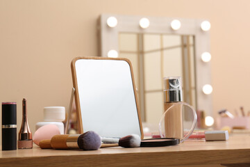 Different cosmetics, makeup brushes and mirror on table in living room, closeup