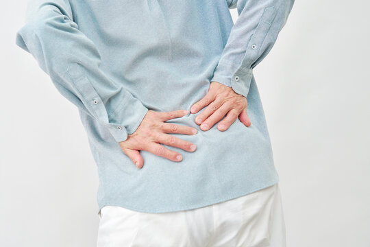 白背景で腰を押さえる男性　顔無し