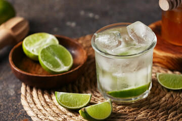 Fototapeta premium Glass of lime infused water on dark background, closeup