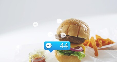 Obraz premium Showing cheeseburger sitting on parchment at tabletop studio with fries, jars and blue 44 bubble