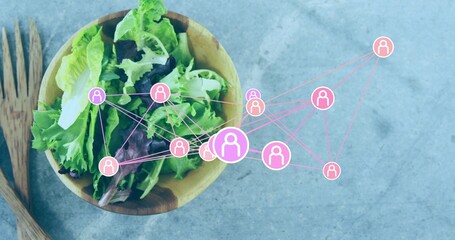 Showing wooden bowl with green-purple leaves and wood servers on grey slab, pink icons, copy space © vectorfusionart