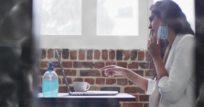 Office woman fixing mask and leaning toward laptop after alert, animated health icons over mask