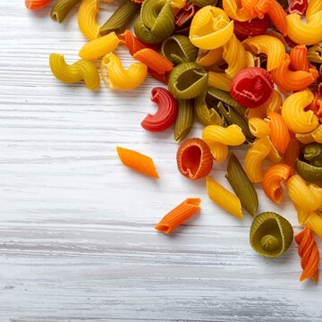 Colorful Dry Pasta Assortment on White Wooden Background.