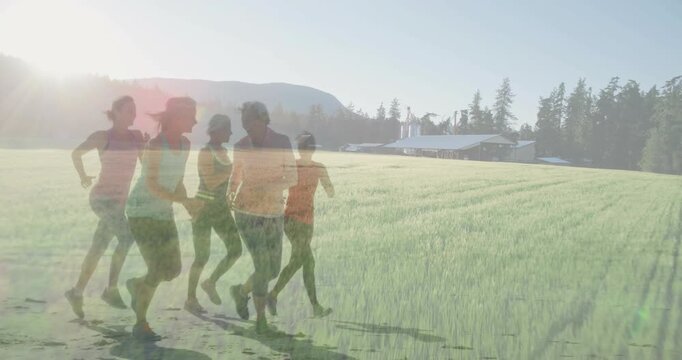 Five female runners entering from left, jogging across field, sunlight causing ghosting for fitness