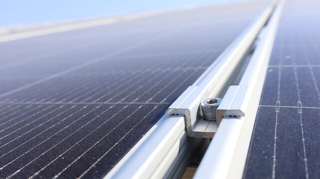 Solar panel lock clamp. Close-up of a set of locks between the panels of solar cells in a solar cell farm with space available for copying by selecting focus.