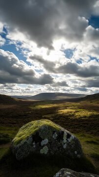 Sunburst Over Mossy Rock In Heather Field On Cloudy Day