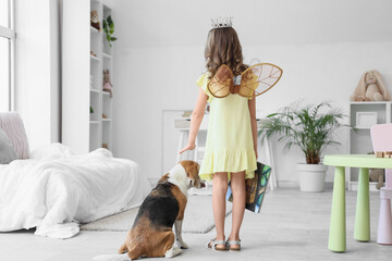 Obraz premium Cute little girl with Beagle dog and book in bedroom