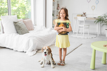 Obraz premium Cute little girl with Beagle dog and book in bedroom
