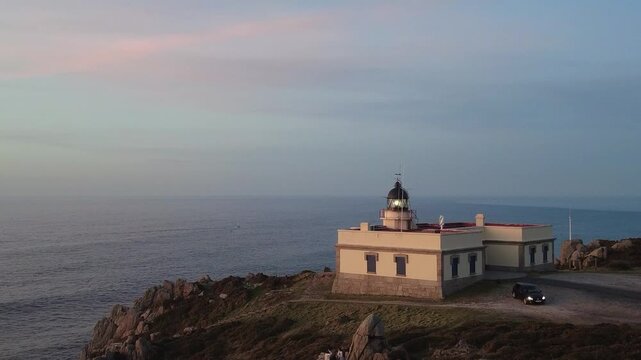 Prior cape lighthouse shining its light at dusk