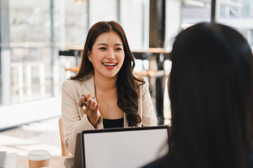 Obraz premium Asian businesswoman talking and smiling during a meeting in a modern office