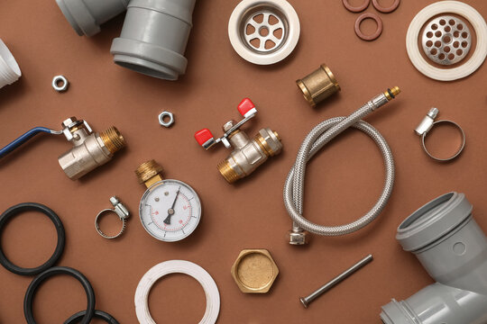 Set of plumber's items on brown background