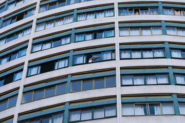 Obraz premium Curitiba, Brasil - Mujer limpiando las ventanas de su apartamento.