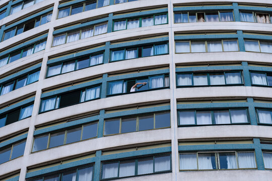 Curitiba, Brasil - Mujer limpiando las ventanas de su apartamento.