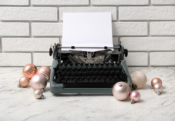 Obraz premium Vintage typewriter with Christmas balls on white table