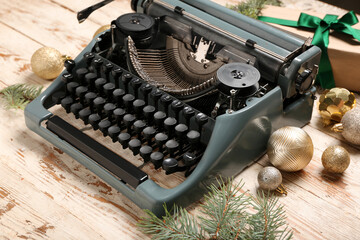 Obraz premium Vintage typewriter with Christmas balls, gift box and fir branches on white wooden background