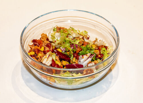 Pile of fresh organic green vegetable leaf salad inside glass bowl
