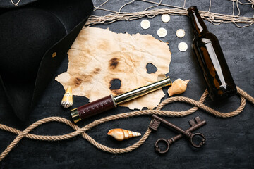 Burnt paper with pirate hat, coins, rope and seashells on dark background © Pixel-Shot