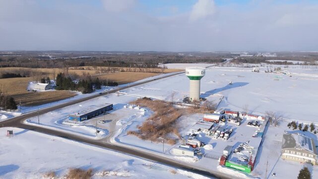Industrial Businesses And Town Of Erin Water Tower During Winter In Ontario, Canada. Orbiting Aerial Shot.