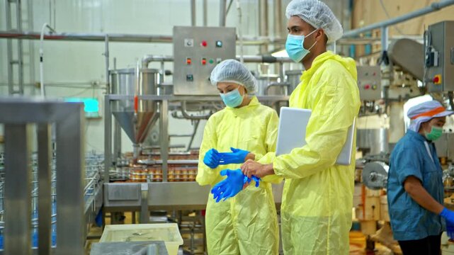 Both of food scientist inspecting canned fish production line and recording quality data in canned fish factory to ensure international safety standards compliance