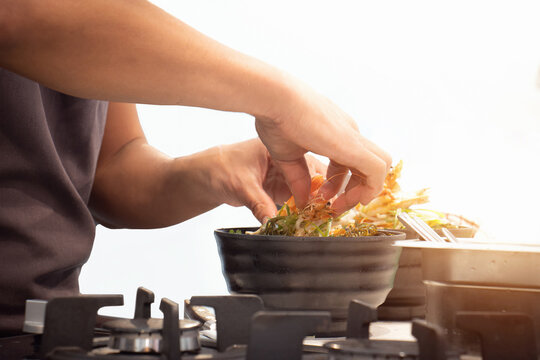 Chef cooking food dish in professional kitchen. Meal recipe preparation on white background.