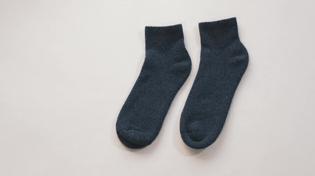 Dark socks on white background minimal studio composition creating clean versatile visual for clothing comfort and everyday lifestyle themes