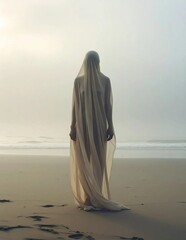 Woman in flowing dress stands on a serene beach at sunrise.