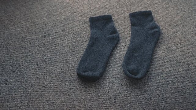 Dark cozy socks on soft fabric surface at home creating warm comfortable atmosphere and calm home lifestyle feeling