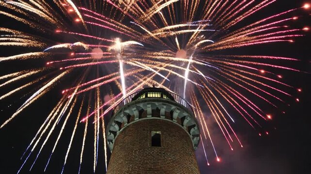Fireworks exploding behind historic lighthouse tower at night, vibrant celebration scene