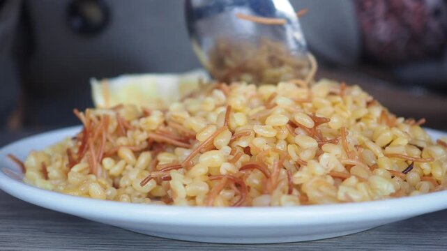 Enjoying delicious bulgur rice dish in local restaurant