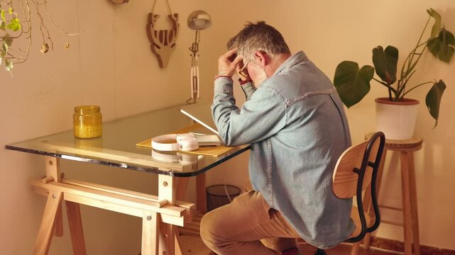 Stressed overwhelmed man experiencing freelance burnout at home office