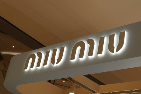 Illuminated Miu Miu luxury brand signage on a modern storefront in a high-end shopping mall on March 30 2026 in Chengdu, China.