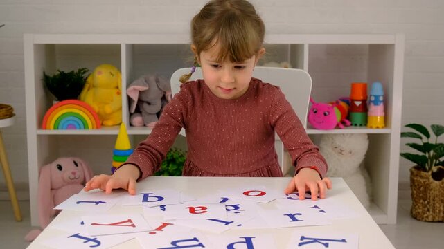 The child learns English letters. Selective focus. Kid.