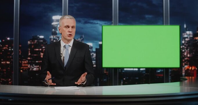 Serious Journalist Sitting at White Desk With Papers and Pen, Presenting Information. Man Positioned Against Vibrant Green Screen, Allowing For Dynamic Virtual Background Keying During Live Broadcast.