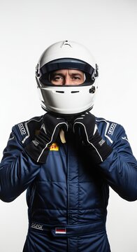 Professional driver in racing suit with helmet and gloves against white backdrop