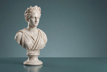 Obraz premium Classical white marble bust of female goddess with wreath on grey background
