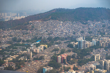 Obraz premium A stunning aerial view of Mumbai captured from an aeroplane window, showcasing the vast urban landscape, dense city layout, and iconic skyline.