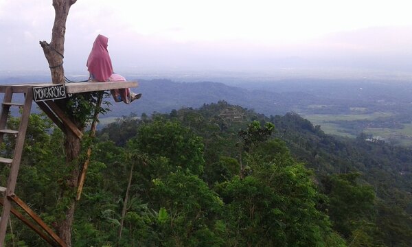 a woman is sitting looking at a beautiful view