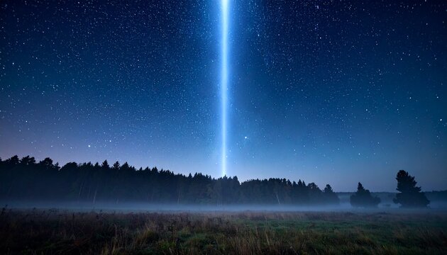 A bright light beam shoots up into the starry night sky above a misty field and forest landscape