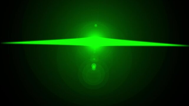 A dark background features a bright green laser pointer beam and a smaller circular glow