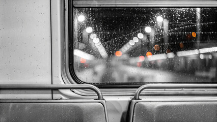 Fototapeta premium Rainy subway window with blurred city lights at night