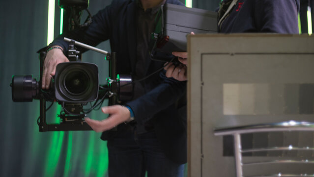 Media production team calibrating professional video camera on stabilizer with copy space