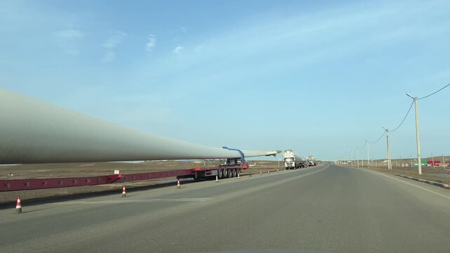 Tasqala, Kazakhstan, 31.03.2026 - Transporting heavy-duty wind turbine blades along the highway on special long-haul trucks.  The renewable energy logistics process.