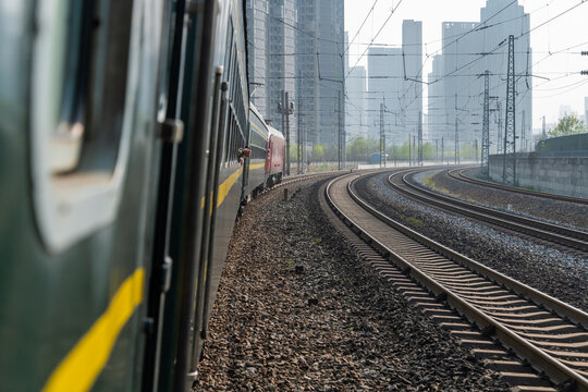 Green Leather Train Traveling Through Urban Building Complex