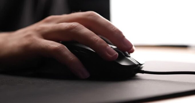 Close-up of a hand using a computer mouse on a sleek mouse pad with a soft-focus background