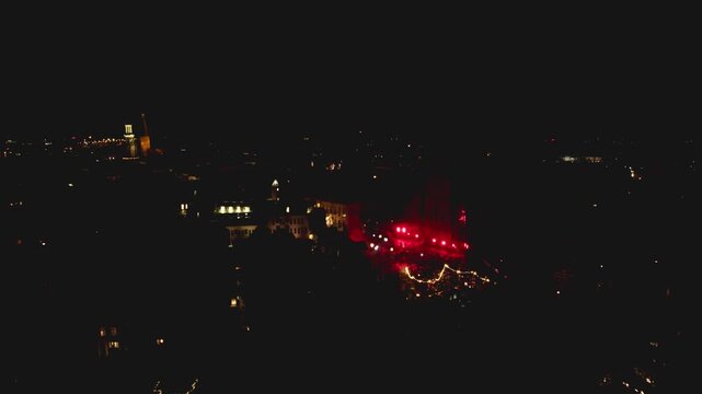 New Years Eve light show in Dutch tower town Zutphen, The Netherlands, with Walburgiskerk lit up by laser and spotlights with urban city center around lit up by streetlights