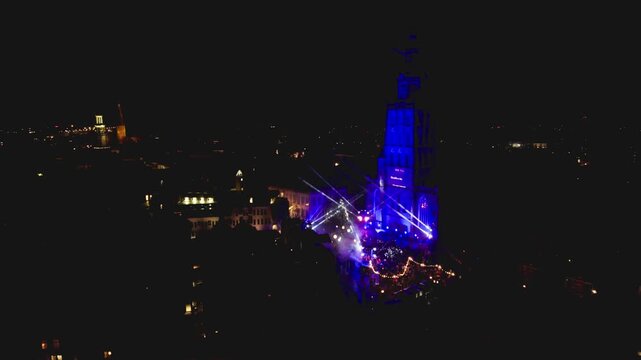 New Years Eve light show in Dutch tower town Zutphen, The Netherlands, with Walburgiskerk lit up by laser and spotlights with urban city center around lit up by streetlights